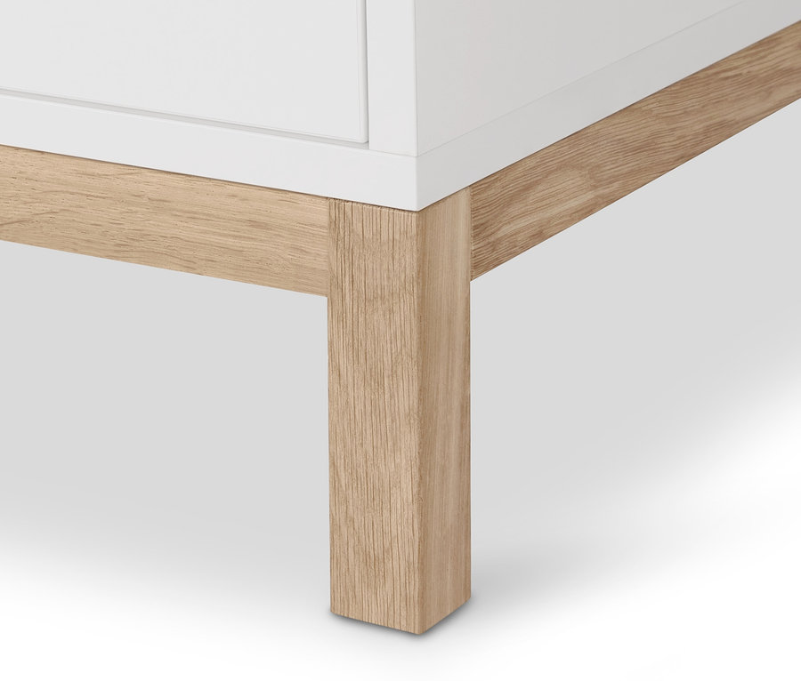 Detal narożnika szafy garderobianej »Eklund« z drewnianą nogą.