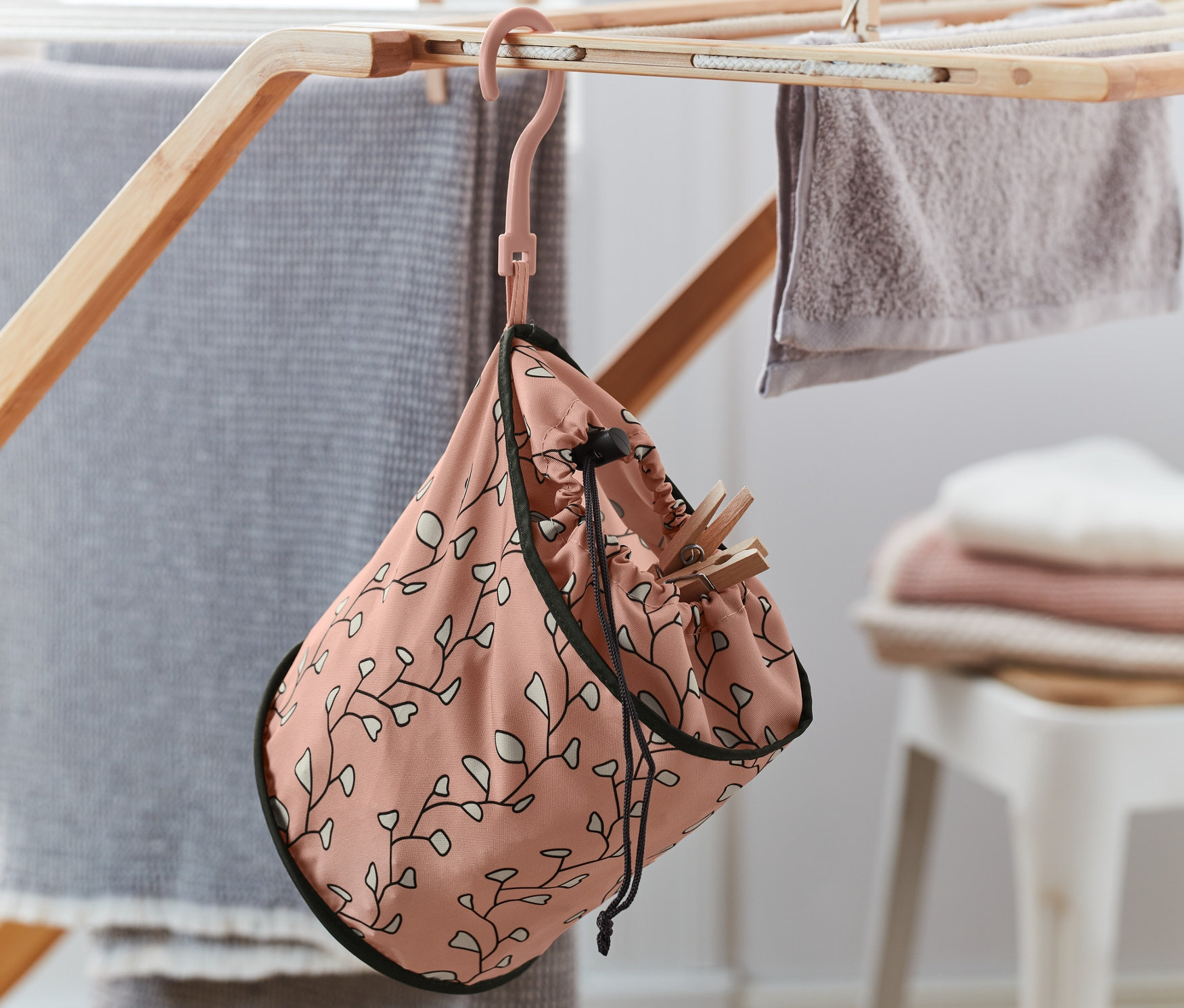 Worek na klamerki do bielizny wisi na suszarce.