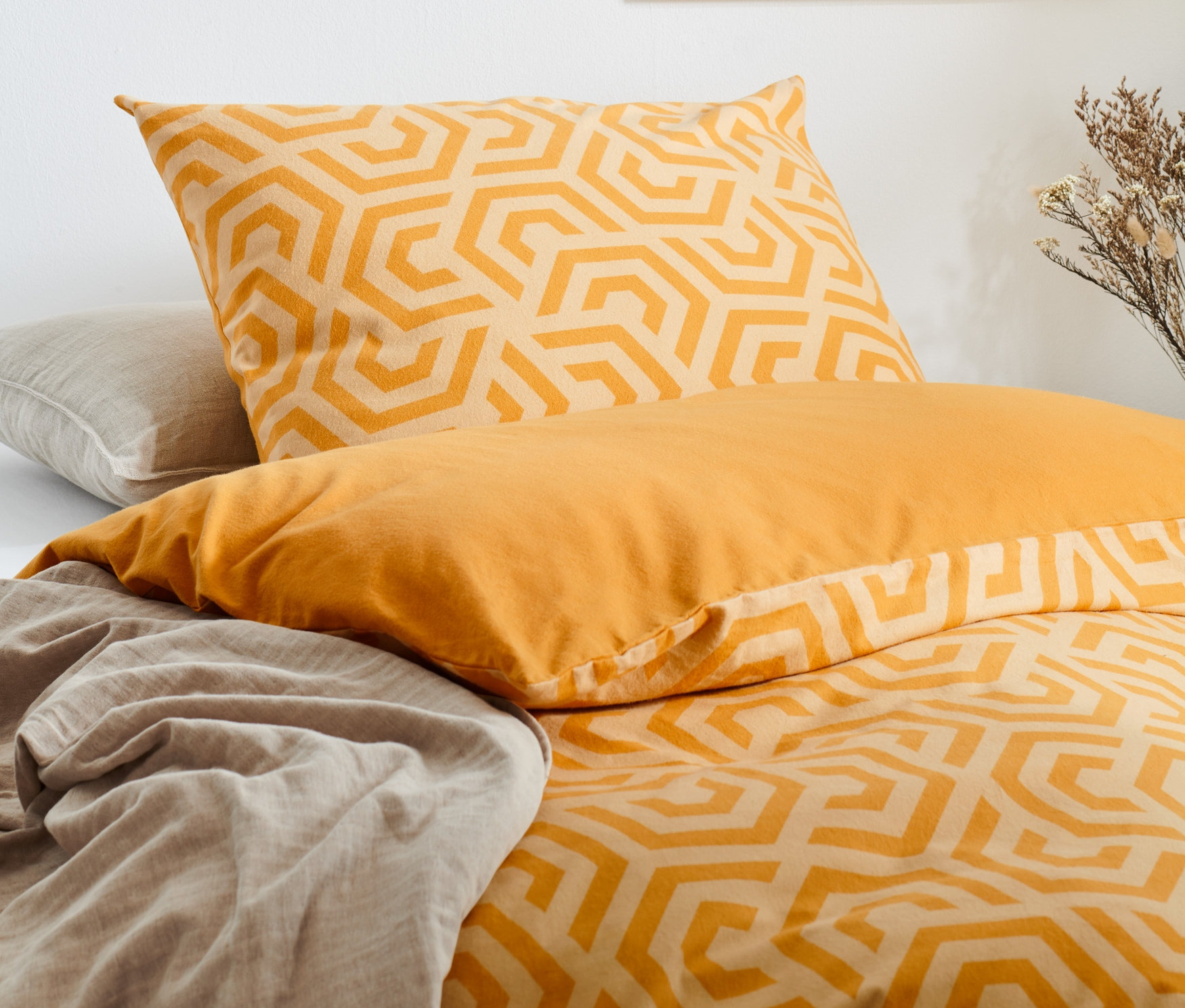 Żółta pościel w geometryczny wzór i prześcieradło.