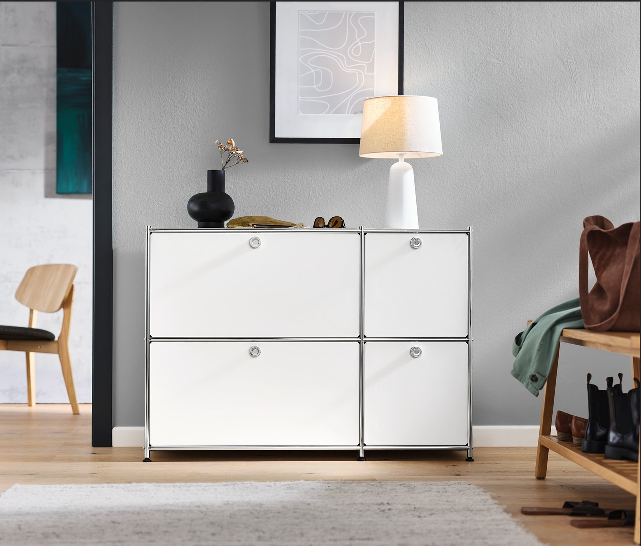 Przedpokój z białą szafką typu sideboard »CN3« z 4 klapami, krzesłem, ławką z półką i białą lampą stołową z kloszem z tkaniny.