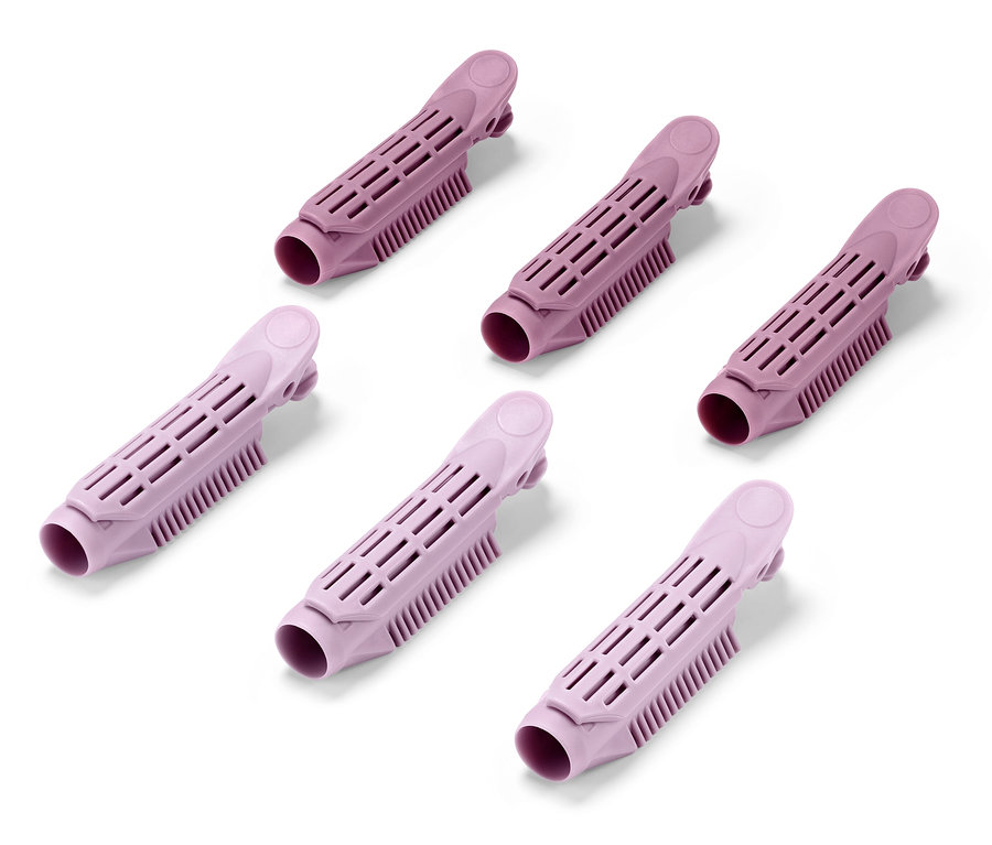 Sześć różowych klipsów do zwiększania objętości włosów u nasady na białym tle.