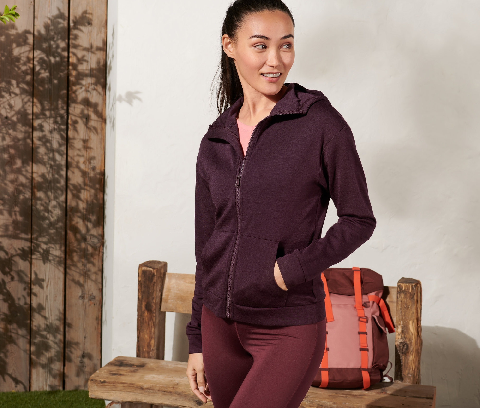 Kobieta ma na sobie fiołkową rozpinaną bluzę z kapturem z wełną z certyfikatem RWS.