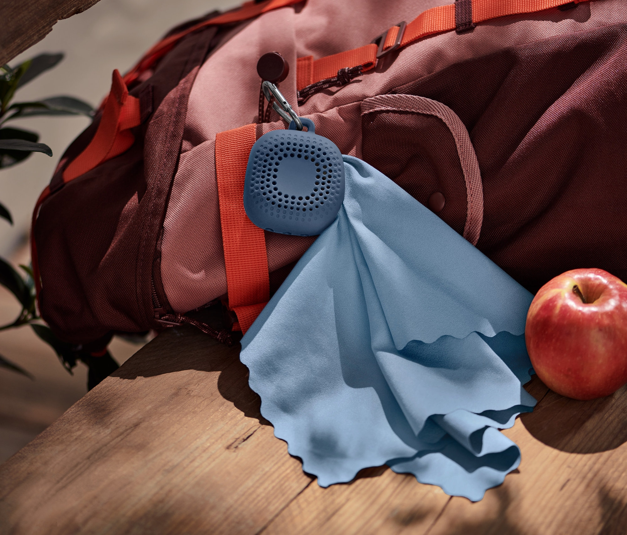 Na plecaku wisi niebieski ręcznik turystyczny.