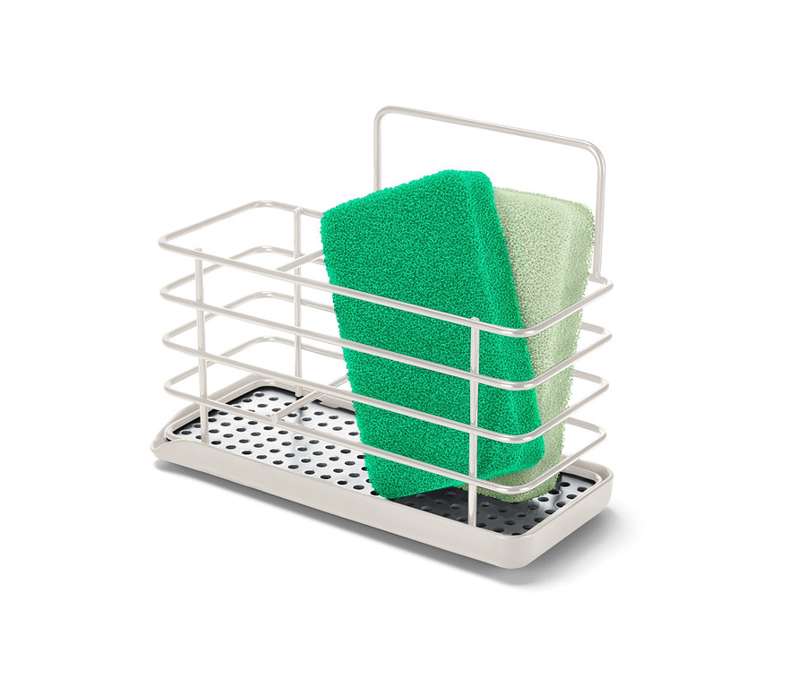 Zielona i jasnozielona gąbka w metalowym stojaku na przybory do zmywania.