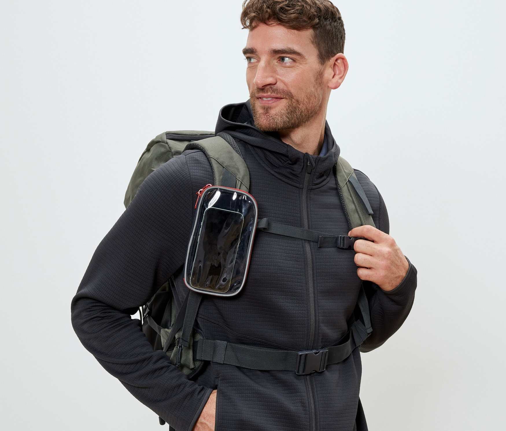 Mężczyzna w plecaku z wielofunkcyjną torebką z okienkiem przymocowaną do paska.