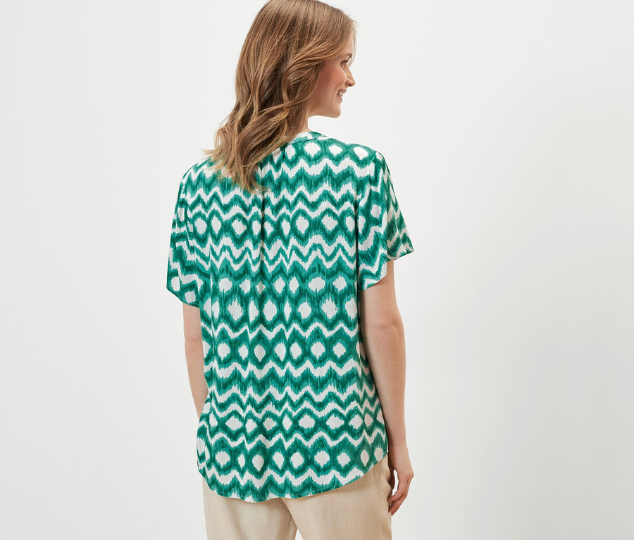 Kobieta ma na sobie tunikę z nadrukiem.