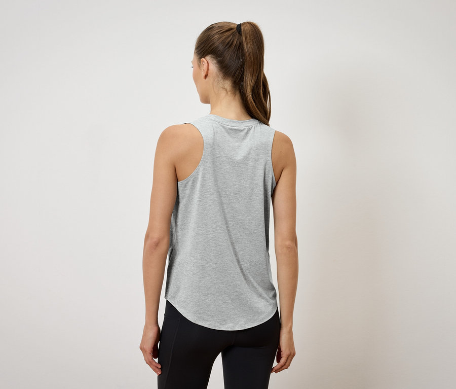 Widok z tyłu kobiety w kucyku, ubranej w szary podkoszulek i czarne legginsy.