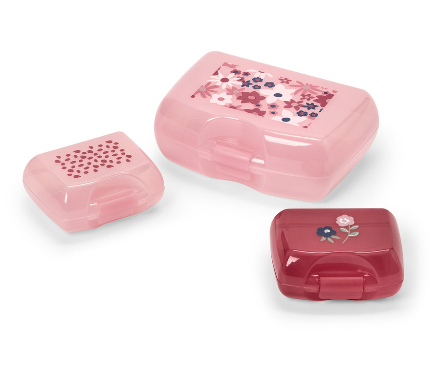 Trzy plastikowe pojemniki na śniadanie w różnych rozmiarach i kolorach z kwiatowymi wzorami.