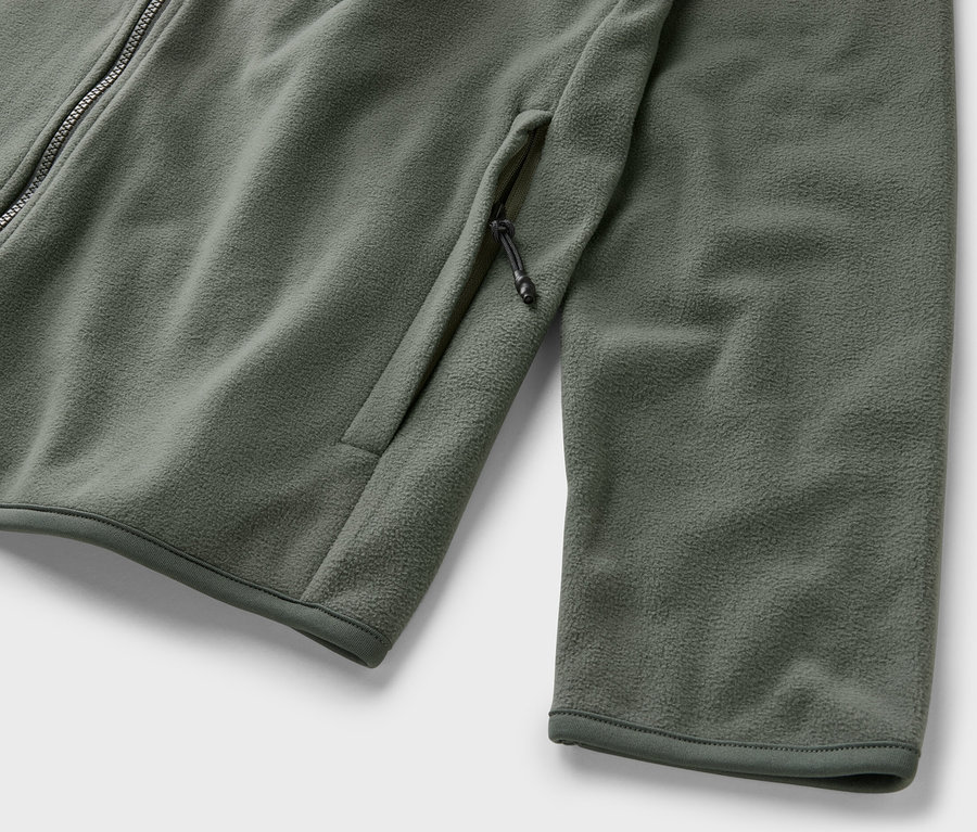 Zbliżenie na bluzę z polaru khaki zapinaną na zamek i z kieszenią.