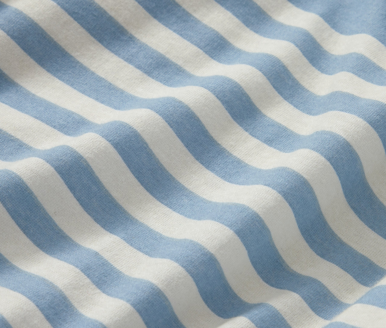 Zbliżenie na pościel zimową jersey w rozmiarze standardowym z niebieskimi i białymi paskami.