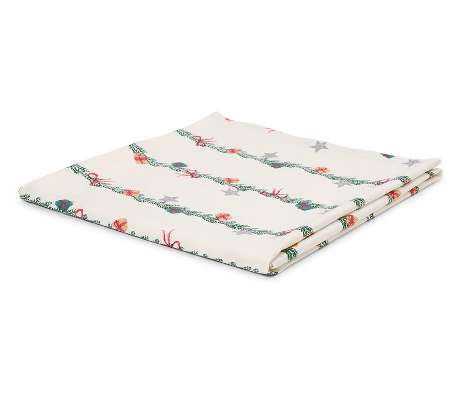 Złożony biały obrus ze świątecznym motywem gałązek, prezentów i gwiazd.