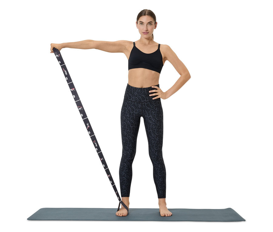 Kobieta ćwiczy z gumą oporową na macie.