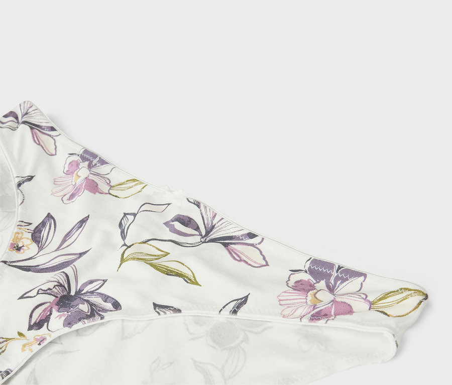 Zbliżenie białej bielizny z kwiatowym wzorem.