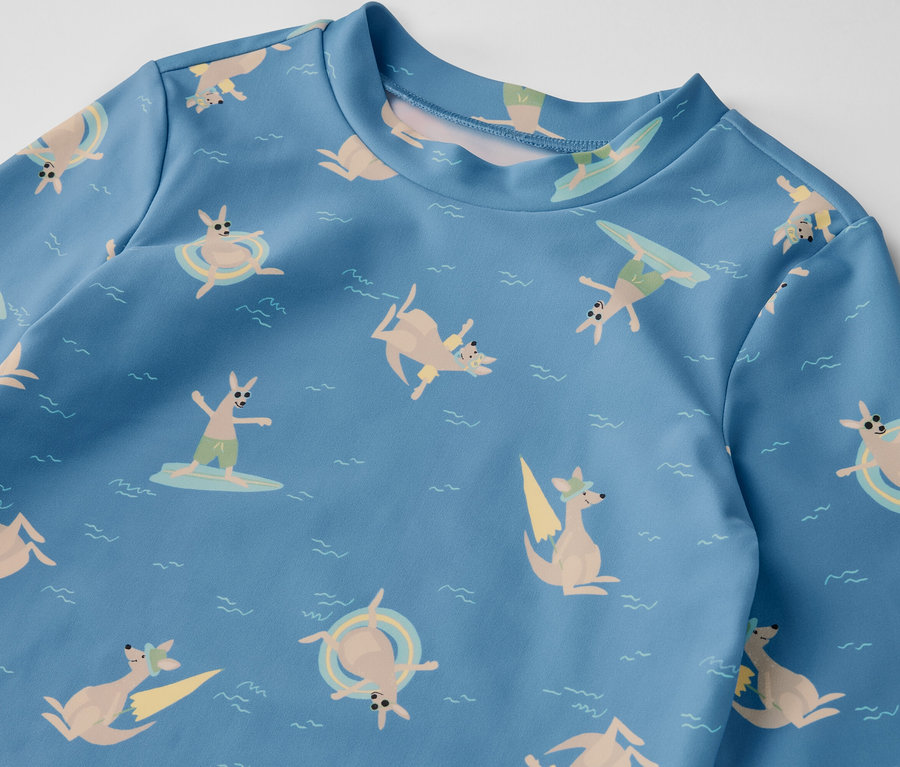 Niebieska koszulka dziecięca z filtrem UV 80, z nadrukiem kangurów surfujących i pływających w morzu.