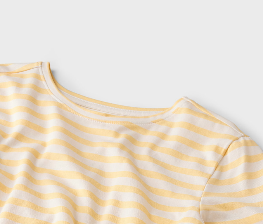 Zbliżenie na T-shirt w żółto-białe paski z okrągłym dekoltem.