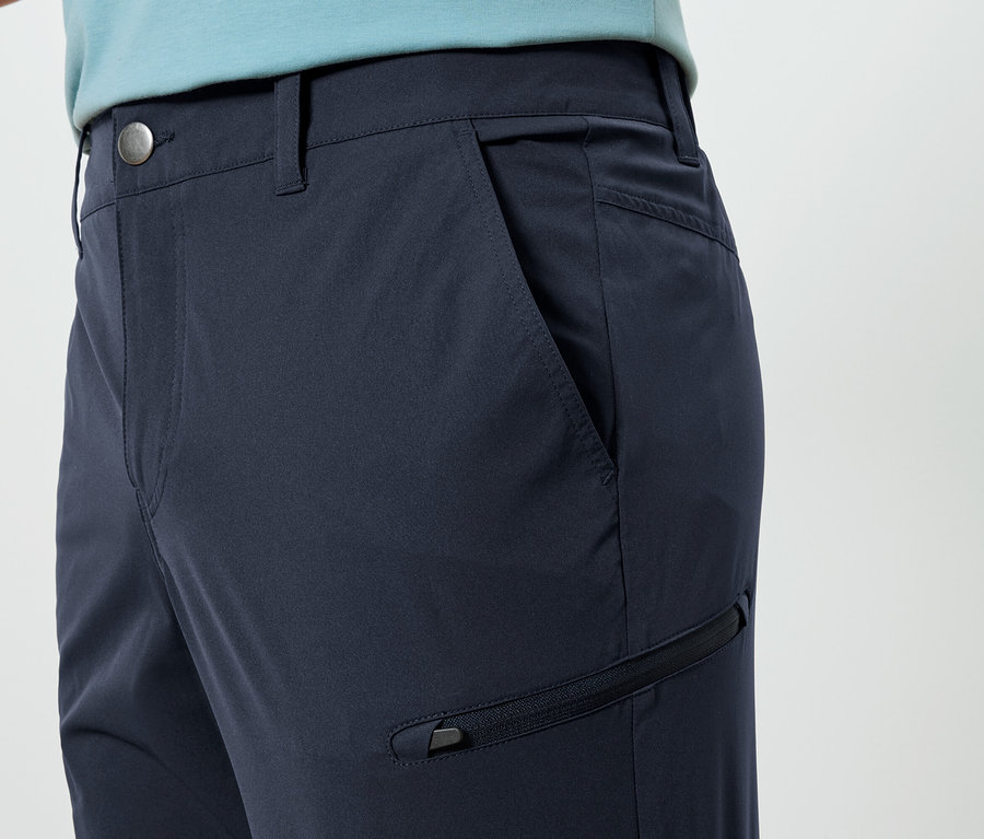 Zbliżenie na granatowe spodnie z kieszenią i zamkiem błyskawicznym.