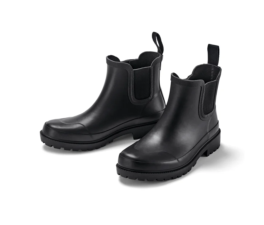 Dwa czarne gumowe buty na białym tle.