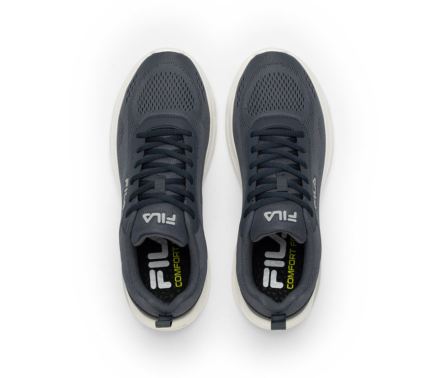 Para ciemnoszarych sneakersów Fila z białymi podeszwami, widok z góry. Buty mają siateczkową cholewkę i białe logo Fila po bokach oraz na wkładkach, z napisem „COMFORT” na wkładkach.
