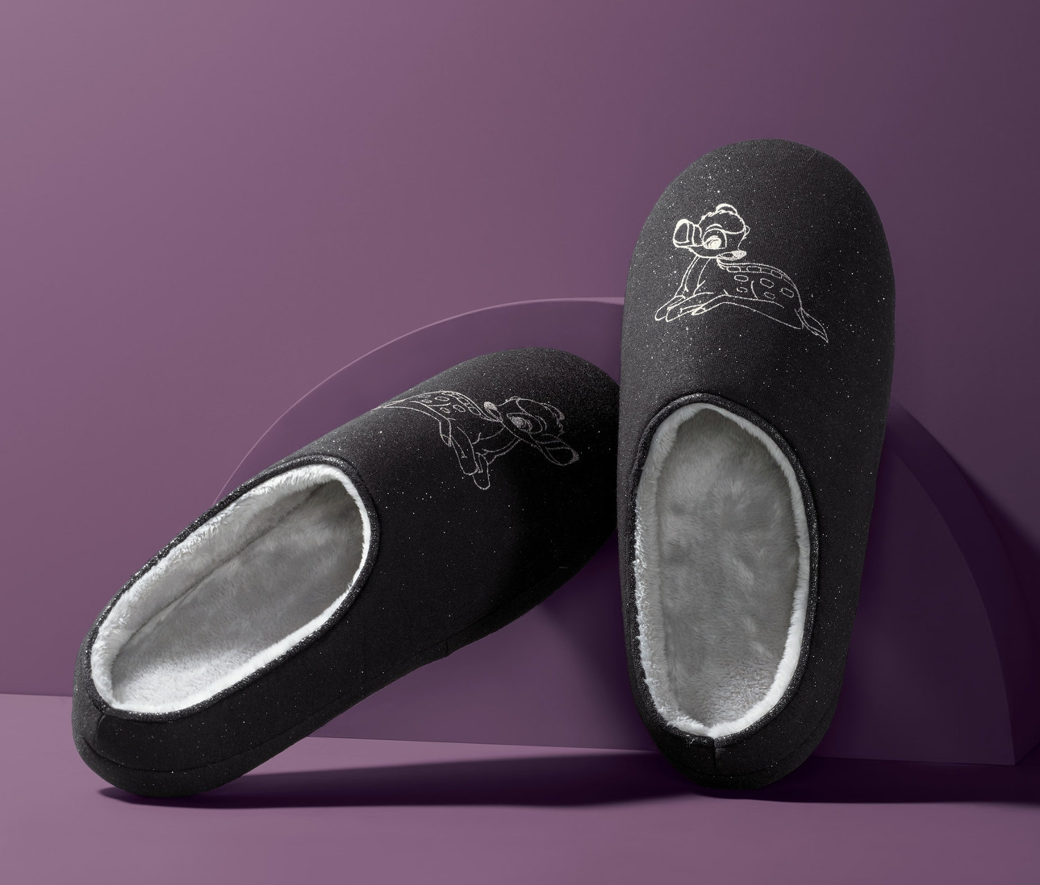 Dwa ciemnoszare kapcie damskie »Disney« z motywem Bambi na fioletowym tle.