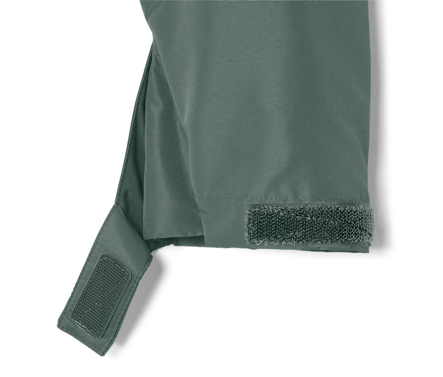 Zbliżenie na zieloną kurtkę na każdą pogodę z zapięciem na rzep na rękawie.