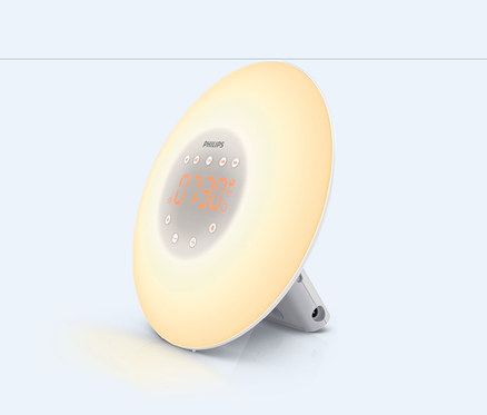 Lampa budząca Philips Wake-Up Light na jasnym tle. Na okrągłym wyświetlaczu świeci godzina 07:30.