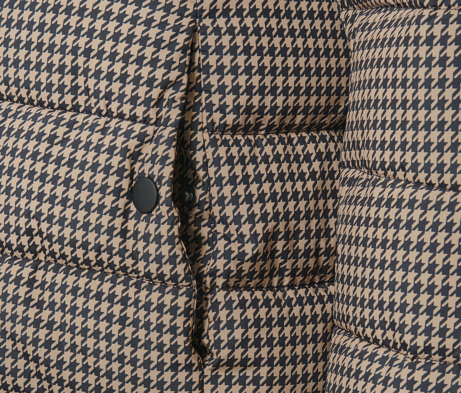 Fragment pikowanej kurtki z kapturem w pepitkę.