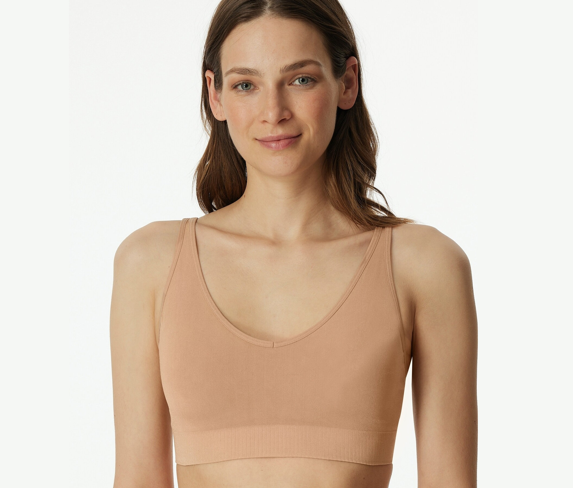 Kobieta nosi miękki biustonosz z wkładkami SCHIESSER, kolor maple.