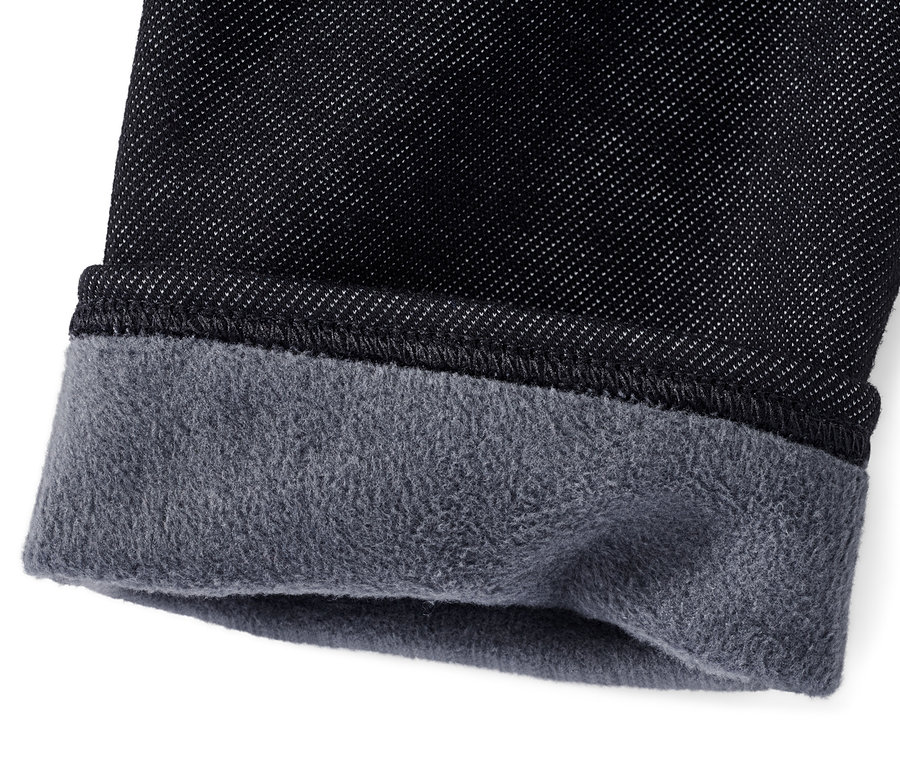 Zbliżenie nogawki ocieplanych legginsów stylizowanych na dżinsy.