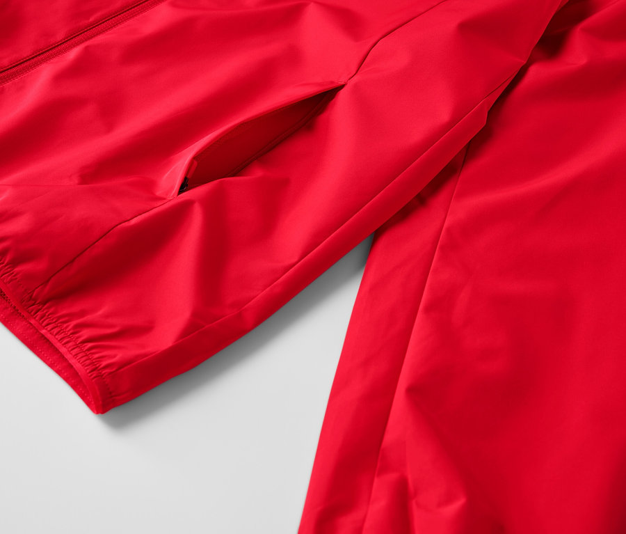 Zbliżenie na czerwoną, przeciwwiatrową kurtkę funkcyjną.