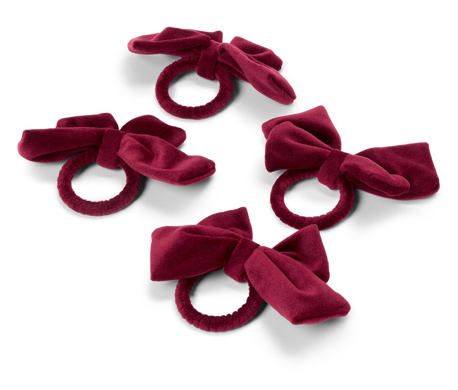 Cztery bordowe, aksamitne pierścienie na serwetki z kokardą na białym tle.