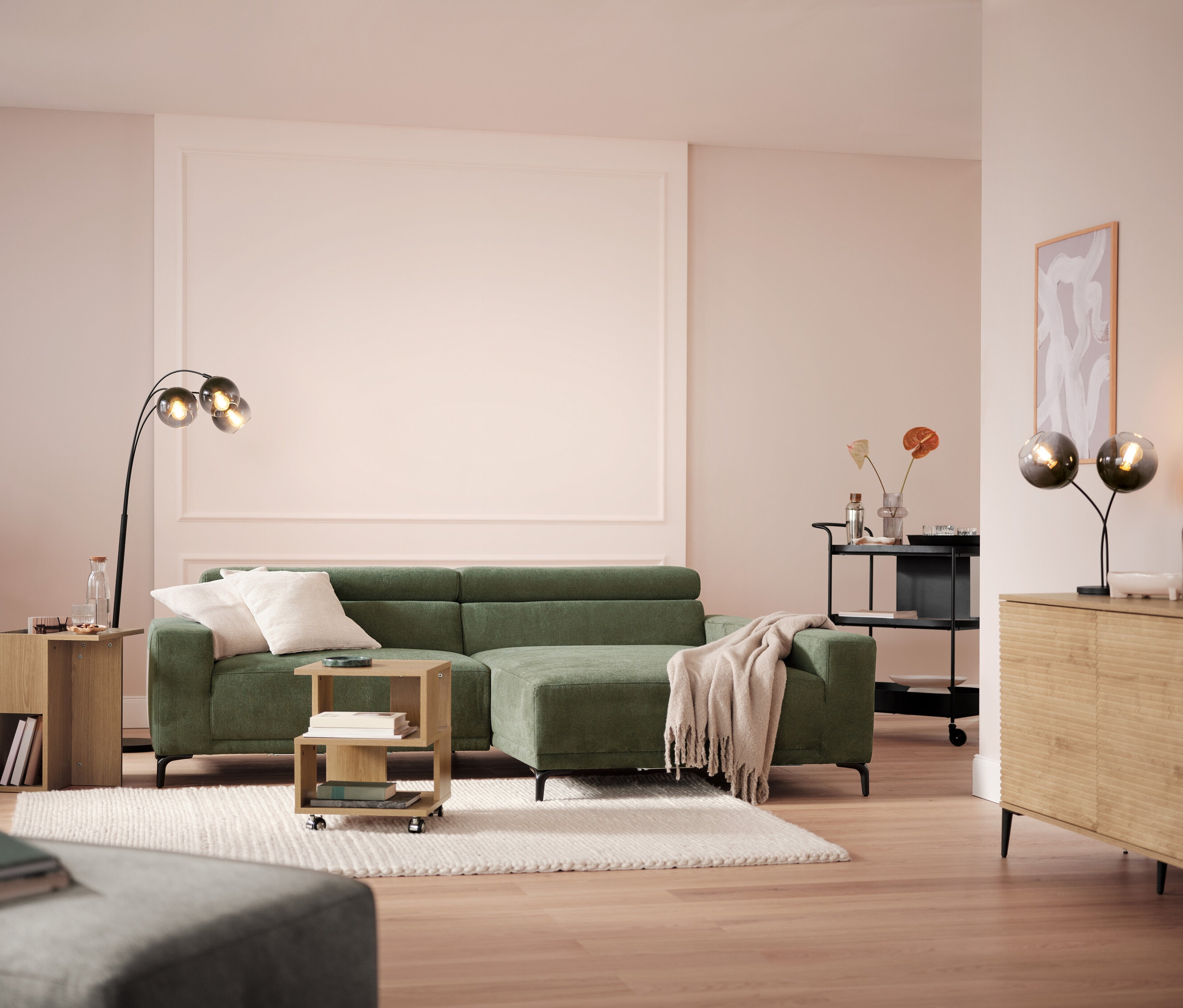 Pokój dzienny z sofą, lampą i wózkiem do serwowania z tacą.