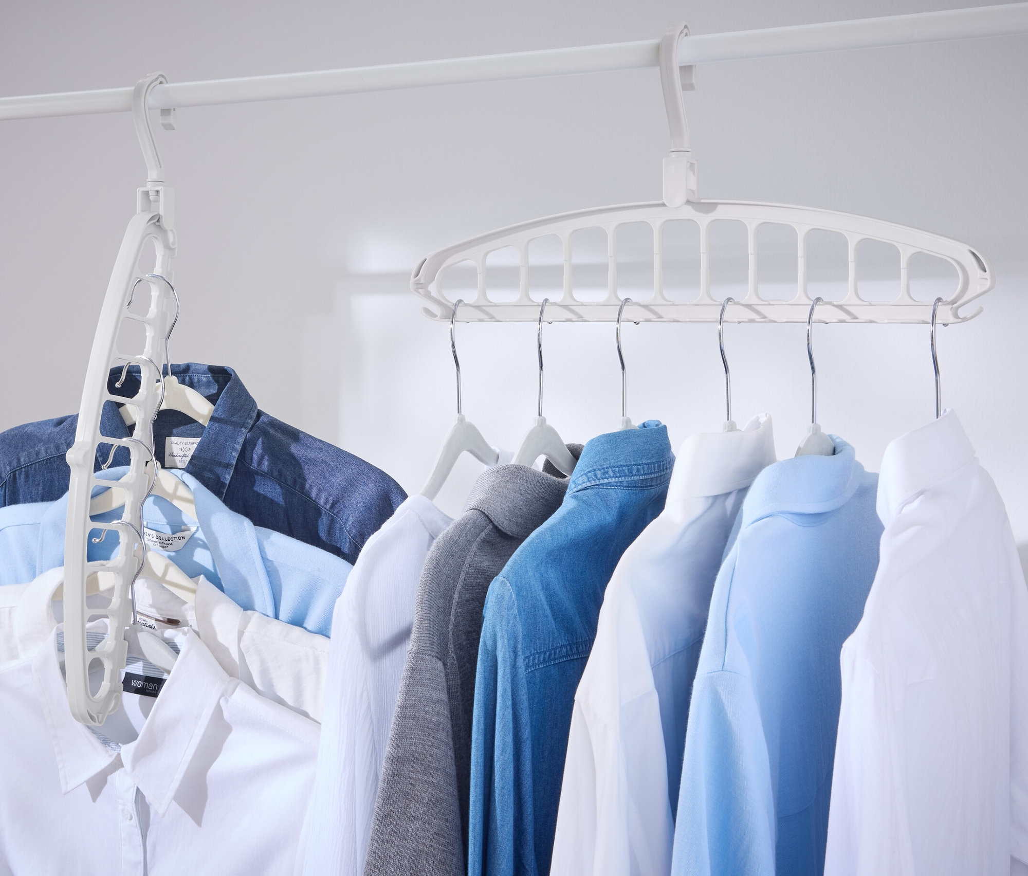 Kilka koszul wisi na białym drążku z wielofunkcyjnymi wieszakami na ubrania, 2 sztuki.