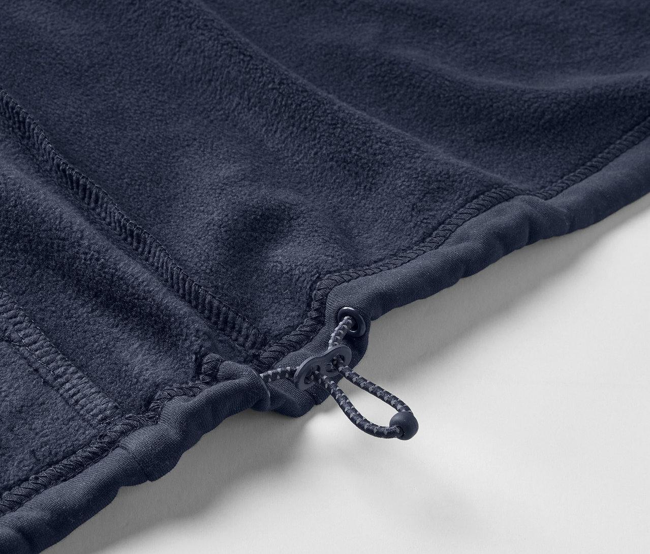 Zbliżenie na granatową kurtkę polarową z zamkiem błyskawicznym.