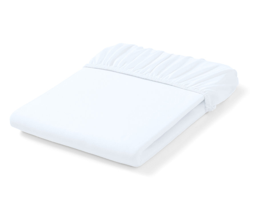 Złożone białe prześcieradło z gumką w rogach.