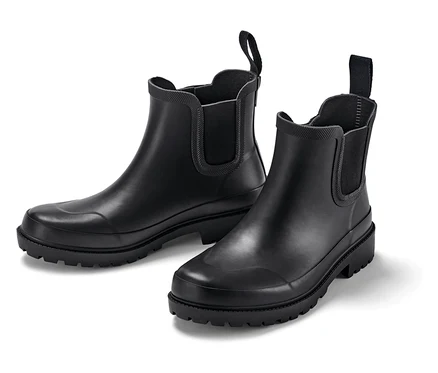 Dwa czarne gumowe buty na białym tle.