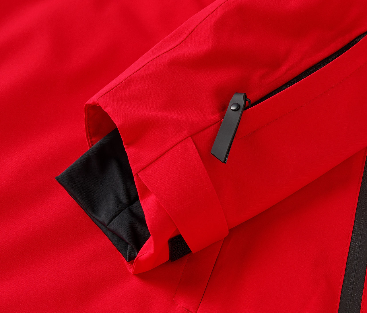 Zbliżenie na czerwoną kurtkę z czarnymi detalami.