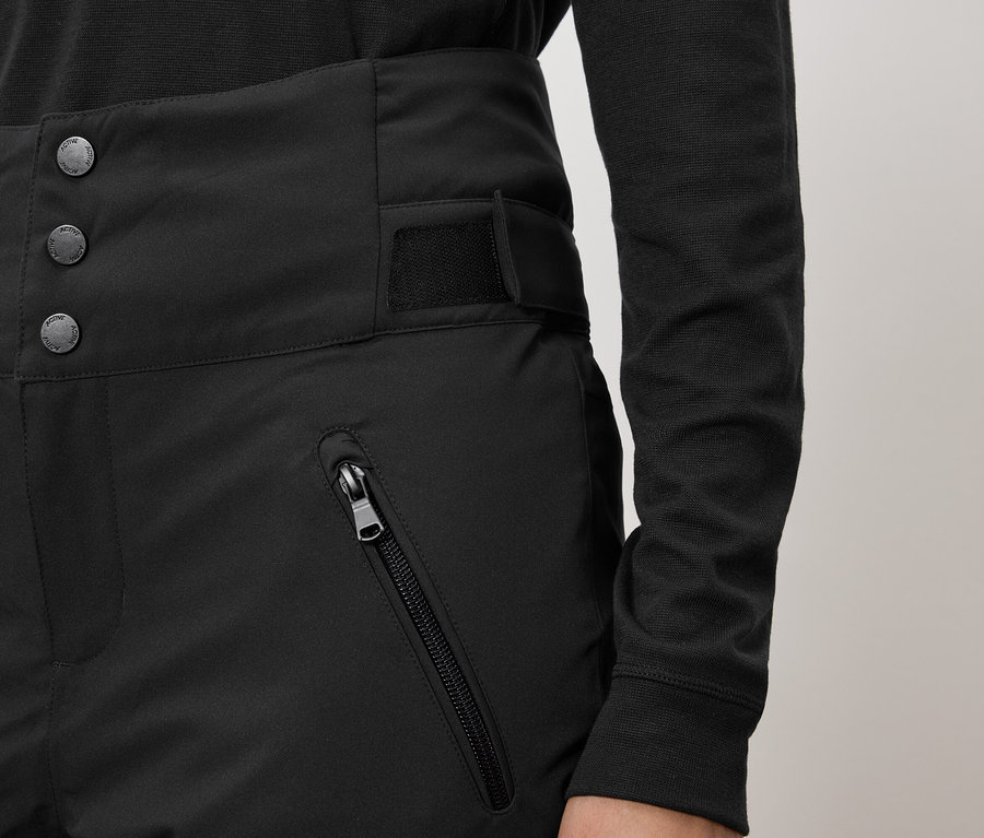 Czarne spodnie z wysokim stanem, zapinane na trzy guziki i kieszeń na zamek.