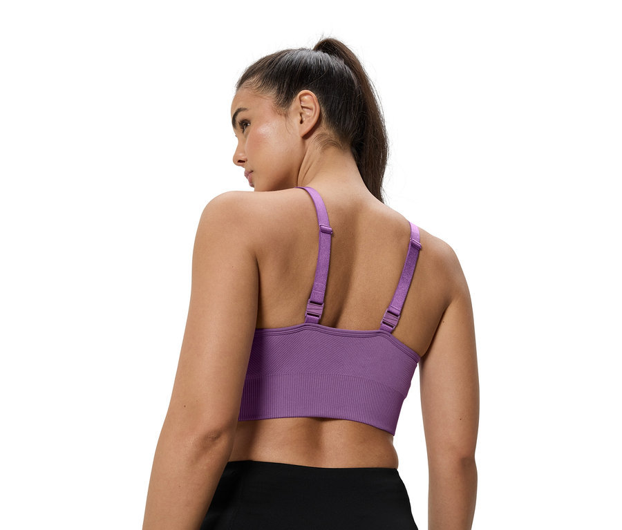 Kobieta ma na sobie fioletowy stanik sportowy.
