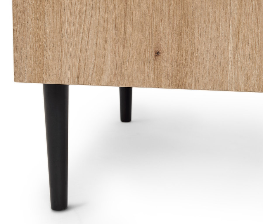 Zbliżenie jasnej drewnianej szafki z dwiema czarnymi nogami.