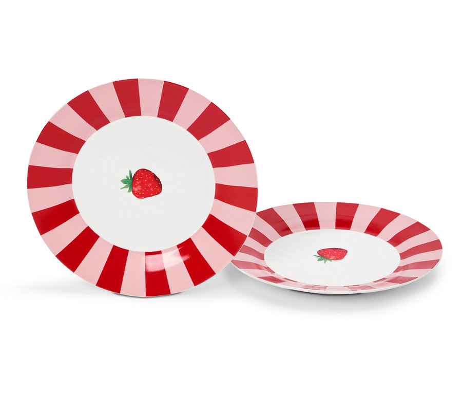 Dwa talerze z czerwono-różowymi paskami i truskawką pośrodku.
