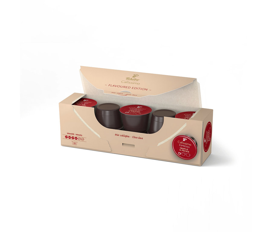 Otwarte opakowanie Tchibo Cafissimo Flavoured Espresso Maple & Pecan, pokazujące 10 ciemnobrązowych kapsułek z czerwonymi wieczkami.