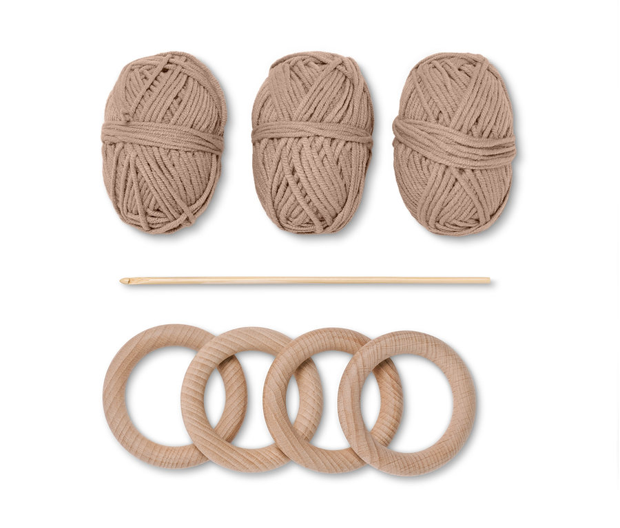 Zestaw do szydełkowania »pierścienie do serwetek«: trzy brązowe motki włóczki, szydełko i cztery drewniane kółka.
