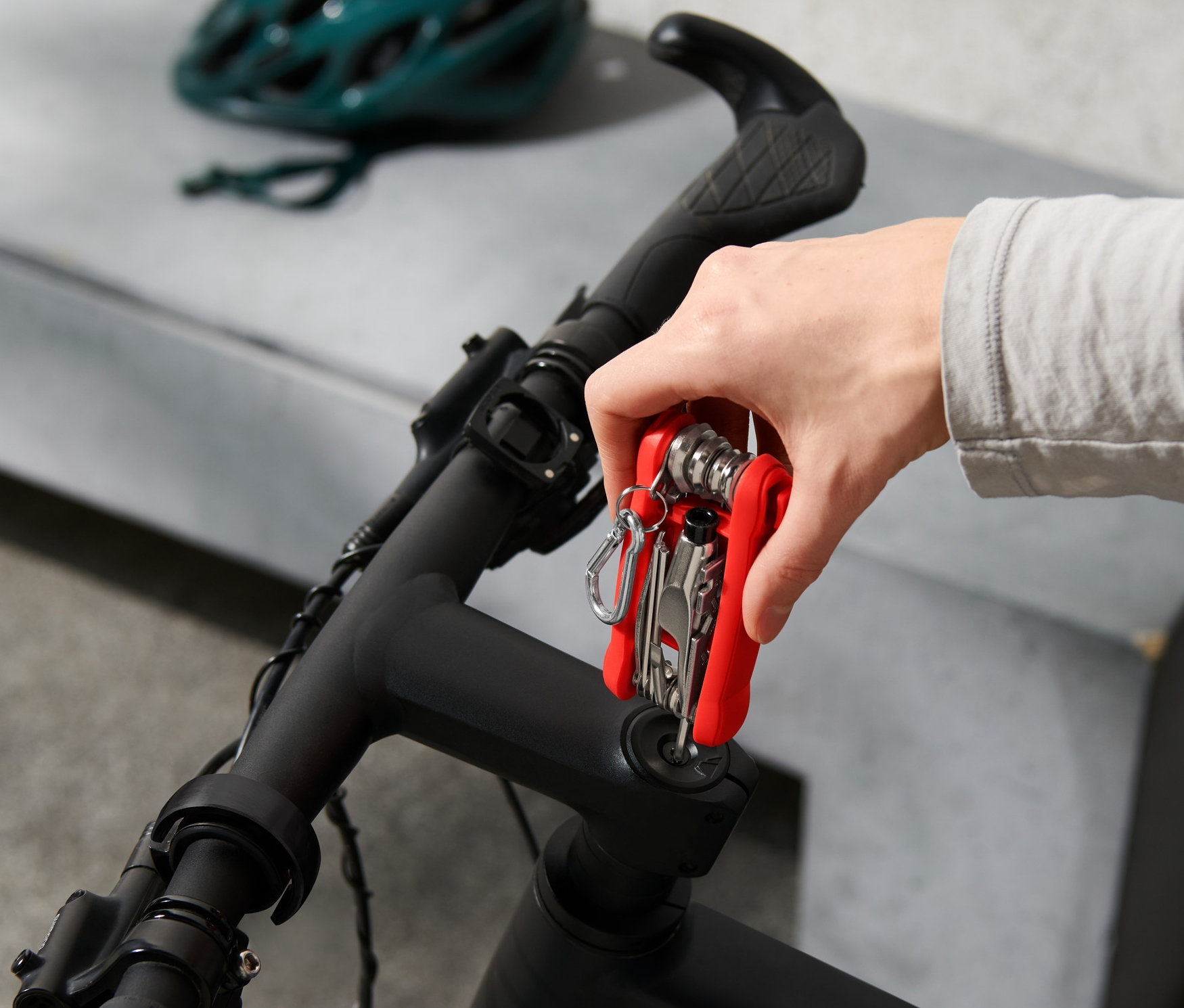 Ręka trzyma wielofunkcyjne narzędzie rowerowe na rowerze.