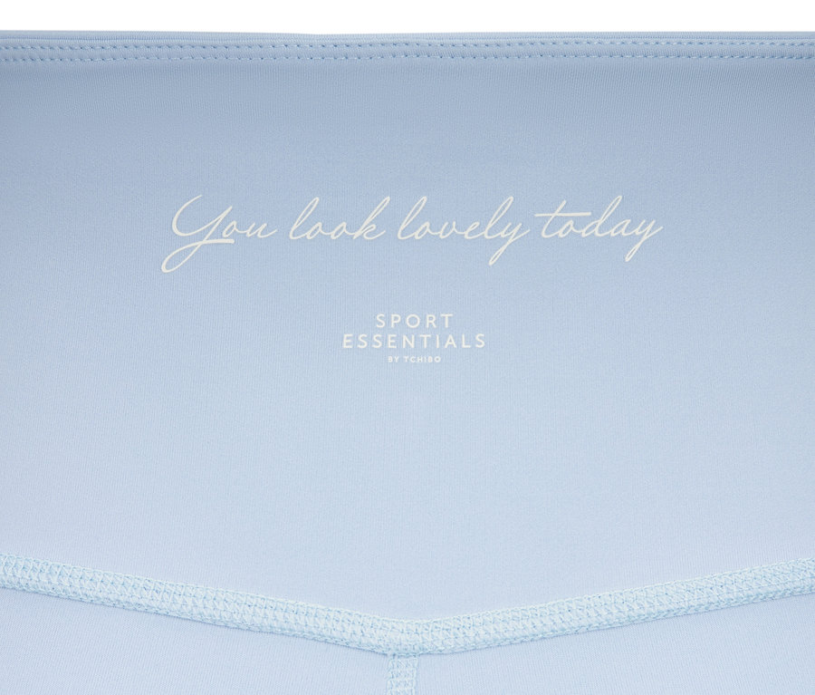 Zbliżenie na błękitne legginsy sportowe »Soft Touch« z napisem.