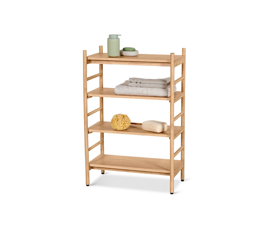 Czteropoziomowy regał ze szczebelkami i regulowanymi półkami. Na górnej półce znajduje się zielony dozownik mydła i mydło, na drugiej półce złożone ręczniki, a na trzeciej półce gąbka morska i pumeks.