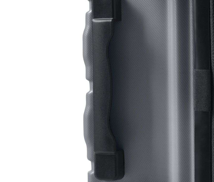 Zbliżenie na szary, duży, pochodzący z recyklingu twardy walizka z czarną rączką.