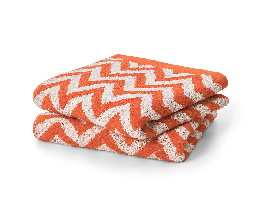 Dwa pomarańczowe ręczniki żakardowe złożone na sobie.