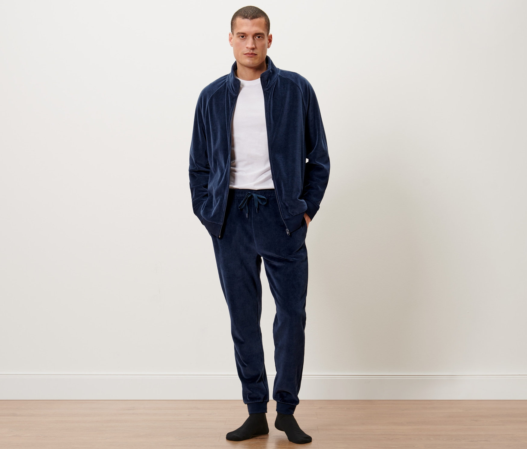 Mężczyzna stoi w dresie z weluru.