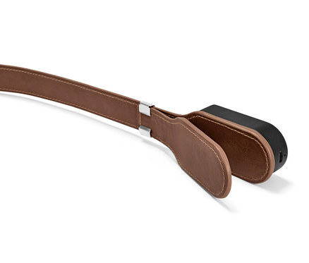 Szczegół lampki do czytania z klipsem, brązowym skórzanym paskiem i czarną lampką.