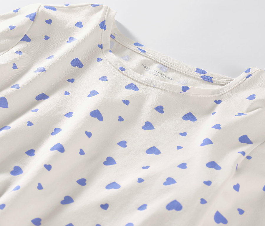 Zbliżenie na białą piżamę w jasnoniebieskie serduszka.